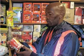  ?? Pictures: ANDISA BONANI ?? INSPECTION: ANC councillor Mncedisi Mbengo inspects tinned food in one of the foreign-owned shops in Mlungisi