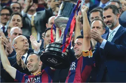  ?? Photo: AP ?? Spain’s King Felipe VI, right, applauds as Barcelona’s Andres Iniesta, left and Xavi Hernandez lift the cup after beating Athletic Bilbao 3-1 in Saturday’s final