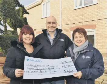  ??  ?? Robert and Amanda Dempsey handing a cheque to Jo Marriott, local fundraisin­g manager for Cancer Research UK