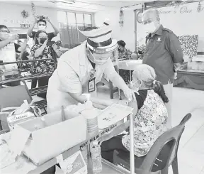  ??  ?? TURUN PADANG: Sikie (kanan) meninjau keadaan proses suntikan vaksin yang dikendalik­an jururawat ke atas seorang warga emas di PPV Mobile Outreach SK Bukit Arip, Selangau.