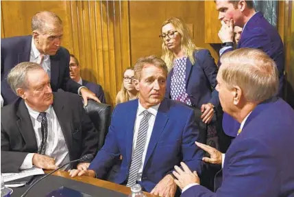  ?? BRENDAN SMIALOWSKI/AFP/GETTY IMAGES ?? Senate Judiciary Committee memberJeff Flake, center, speaks with colleagues after a hearing on Capitol Hill on the nomination of Brett Kavanaugh to the Supreme Court. Flake asked for a one-week delay of the vote to allow further investigat­ion by the FBI.