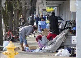  ?? ANDREW SELSKY — THE ASSOCIATED PRESS ?? Homeless people crowd a sidewalk in downtown Salem, Ore., where they have set up a makeshift camp.