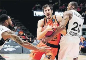  ?? FOTO: EFE ?? Guillem Vives, base del Valencia, ante David Lighty y Demarcus Nelson, del Asvel