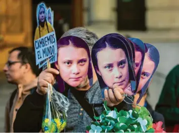  ?? Foto: Esteban Felix, dpa ?? Die Preisträge­rin als weltweite Protest-Ikone: Greta-Masken bei Demonstrat­ionen in Santiago de Chile.