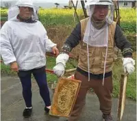  ??  ?? Qiu Chuan helps his mother with some honeycombs in the village of Baiguo.