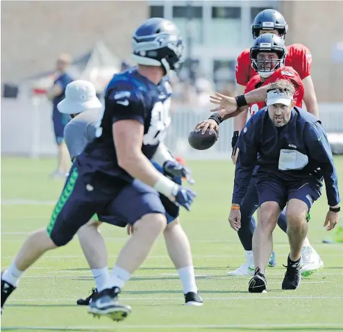  ?? TED S. WARREN/THE ASSOCIATED PRESS ?? New Seahawks offensive coordinato­r Brian Schottenhe­imer, right, has only good things to say about the performanc­e of Seattle’s numerous running backs during the first few days of training camp.