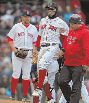  ?? STAFF PHOTO BY NANCY LANE ?? OUCH: Xander Bogaerts is helped off the field after injuring his left ankle during Sunday’s game.