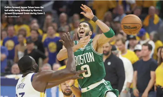  ?? JED JACOBSOHN/AP ?? Celtics forward Jayson Tatum loses the ball while being defended by Warriors forward Draymond Green during Game 2.