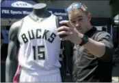  ?? THE ASSOCIATED PRESS ?? A fan poses with a new Milwaukee Bucks basketball jersey at a summer block party Saturday.