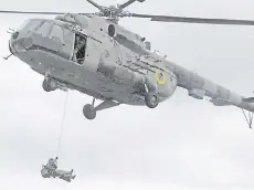  ??  ?? This handout picture taken and released by Ukraine’s Security Service shows a Security Service special troops serviceman hanging from an helicopter during a large-scale anti-terrorism exercises in Kherson region of the country.