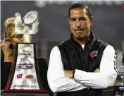  ?? RICK SCUTERI / AP ?? Wisconsin head coach Luke Fickell, the former Ohio State and Cincinnati coach, stands with the Guaranteed Rate Bowl trophy in Phoenix after his Badgers beat Oklahoma State 24-17 on Dec. 27.