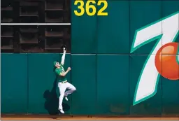  ?? THEARON W. HENDERSON — GETTY IMAGES ?? The Athletics’ Mark Canha makes a leaping catch at the wall taking a hit away from Yoan Moncada of the White Sox during the third inning of Game 2.