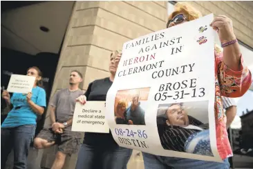  ?? JOHN MINCHILLO/ASSOCIATED PRESS ?? Carol DeMoss holds a sign Sept. 11 as heroin awareness and advocacy groups in Cincinnati rally on the steps of the Hamilton County Justice Center to demand action after a wave of overdoses hit the region.