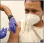  ?? CHARLES REX ARBOGAST THE ASSOCIATED PRESS ?? Julio Figuera, 43, receives a vaccine at the Cook County, Ill., medical clinic last month in Chicago. Figuera developed pneumonia since arriving in the U.S.