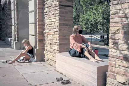  ?? Photos by Chet Strange, Special to The Denver Post ?? Maggie Silver, left, and Katie Morton sit outside their dorm on Wednesday at the University of Colorado. As coronaviru­s cases have spiked on the Boulder campus, county health officials have cracked down, prohibitin­g gatherings of people age 18 to 22.