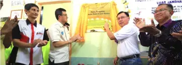  ??  ?? Dr Rundi (second right) signing the plague to symbolical­ly officiate at the RES project in Rh Alo Riang in Ulu Suai Niah.