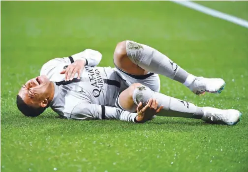  ?? ?? ↑
Paris Saint-germain’s Kylian Mbappe lies on the ground after getting injured during their French League match against Montpellie­r.