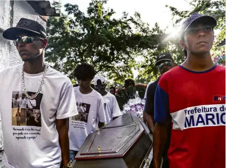  ?? Ian Cheibub/Folhapress ?? Enterro de três dos cinco jovens mortos em um conjunto habitacion­al em Maricá, no Grande Rio, na manhã de domingo