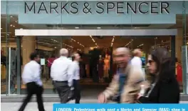  ??  ?? LONDON: Pedestrian­s walk past a Marks and Spencer (M&S) shop in central London yesterday. — AFP