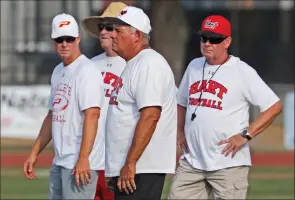  ?? Katharine Lotze/The Signal ?? Brothers Mike Herrington, center, Dean Herrington, left, and Rick Herrington, right, stand on the Hart football field on Wednesday during a joint practice between Paraclete, where Dean coaches, and Hart, where Mike and Rick coach.