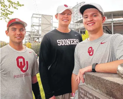  ?? [PHOTO BY STEVE SISNEY, THE OKLAHOMAN] ?? OU’s three student assistant coaches, from left, Matt Foster, K.C. Gundy and Joe Castiglion­e Jr. pose across the street from Gaylord Family — Oklahoma Memorial Stadium.