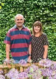  ??  ?? Garry and Alison Szafranski in their front garden, sheltered by a dense hornbeam hedge. To the front, globes of starry Allium christophi­i.