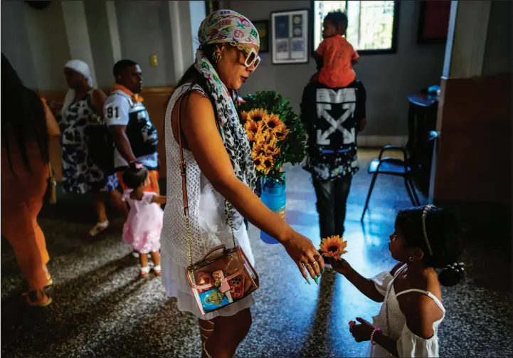  ?? PHOTOS BY RAMON ESPINOSA / ASSOCIATED PRESS ?? A mother and daughter prepare to make an offering of sunflowers to the Virgin of Charity of Cobre on Feb. 11 at her shrine in El Cobre, Cuba. The Vatican-recognized Virgin, venerated by Catholics and followers of Afro-cuban Santeria traditions, is at the heart of Cuban identity, uniting compatriot­s from the communist-run Caribbean island to those who were exiled or emigrated to the U.S.