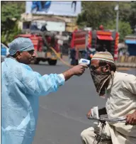  ??  ?? A health worker checks the temperatur­e of a man during the lockdown in Ahmedabad, India