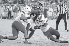  ?? AL DIAZ adiaz@miamiheral­d.com ?? Florida State running back Cam Akers is taken down by Miami’s Pat Bethel, left, and Shaquille Quarterman in the fourth quarter Saturday in Tallahasse­e.