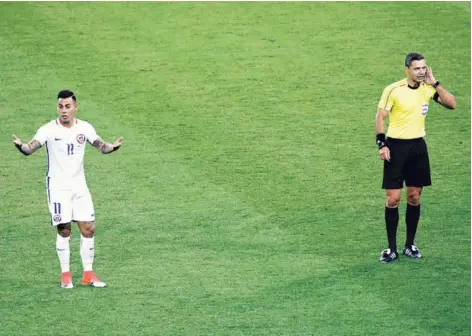  ?? FOTO: EFE ?? ►► Vargas no entiende nada tras anotar por Chile, mientras el árbitro espera el dictamen del VAR.