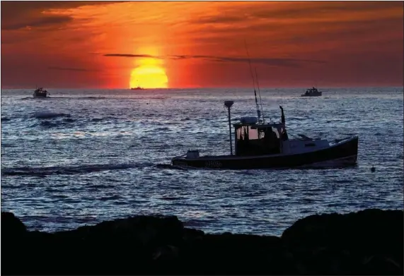  ?? (File Photo/AP/Robert F. Bukaty) ?? Lobster fishermen work at sunrise Sept. 8 off Kennebunkp­ort, Maine. The waters off New England logged the second-warmest year in their recorded history in 2022, according to researcher­s.