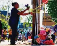  ?? Matt Rourke/Associated Press ?? A person tends to a memorial outside the scene of the supermarke­t shooting in Buffalo, N.Y.