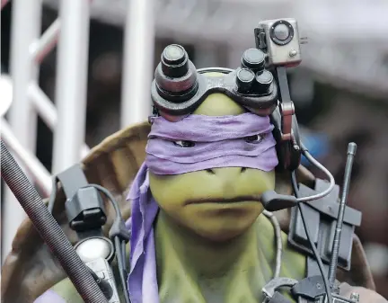  ?? ROBYN BECK/AFP/GETTY IMAGES FILES ?? Regency Village Theater in Los Angeles featured a statue of Donatello at the premiere of Teenage Mutant Ninja Turtles in 2014. L.A.’s unique culture and laid-back style also spread to the Kings team as players and coaches brought their kids to practice...