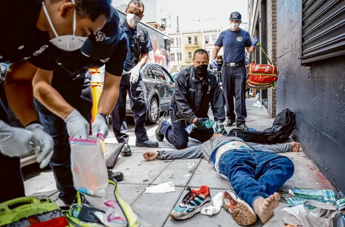  ?? Gabrielle Lurie/The Chronicle 2021 ?? San Francisco Fire Department Lt. Jonathan Baxter works to save a man named Ryan during an apparent fentanyl overdose on Aug. 3, 2021, on Olive Street.