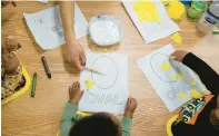  ?? ?? Children work on arts and crafts together at the Blanche Foxworthy Infant Care Center.