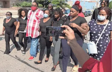  ?? PHOTOS BY MARK HOFFMAN / MILWAUKEE JOURNAL SENTINEL ?? Jacob Blake, third from left, and Julia Jackson, fourth from left, the parents of Jacob Blake, 29, walk with family members to a news conference Tuesday in Kenosha. The younger Blake was shot in the back by Kenosha police.