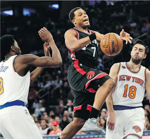  ?? — THE ASSOCIATED PRESS ?? Toronto Raptors’ Kyle Lowry, centre, loses control of the ball on the way to the basket during NBA action against the New York Knicks on Sunday in New York. Lowry had 17 points in Toronto’s 110-97 victory as the Raptors reached the 50-win mark.