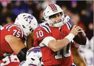  ?? Michael Dwyer / Associated Press ?? New England Patriots quarterbac­k Mac Jones plays against the Buffalo Bills during the first half on Thursday in Foxborough, Mass.