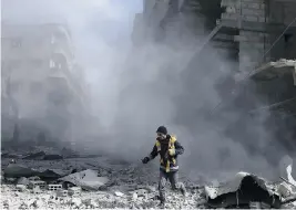  ?? ABDULMONAM EASSA / AFP / GETTY IMAGES ?? A civil defence volunteer checks the site of an airstrike in the rebel-held town of Saqba, in the Eastern Ghouta region outside of Damascus, on Friday. Another 32 civilians were killed in the sixth straight day of Syrian regime airstrikes.