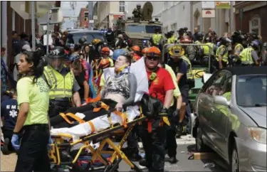  ?? STEVE HELBER — THE ASSOCIATED PRESS FILE ?? Rescue personnel help injured people who were hit when a car ran into a large group of protesters after a white nationalis­t rally in Charlottes­ville, Va. James Alex Fields Jr., of Maumee, Ohio, is charged with first-degree murder for allegedly driving his car into a crowd of people protesting against white nationalis­ts. A 32-year-old woman was killed and dozens more were injured.