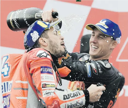  ?? Picture: AFP ?? CELEBRATIO­N. Race winner Andrea Dovizioso is sprayed with champagne by third placed Pol Espargaro after the Valencia Grand Prix at the Ricardo Tormo racetrack in Cheste yesterday.