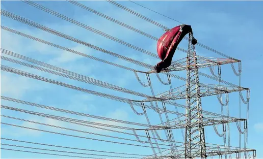  ?? AP ?? A hot air balloon sits on top of the pylon of a high-voltage power line in Bottrop yesterday after it snagged on the line the evening before.