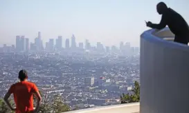  ?? (AFP) ?? People gather at Griffith Observator­y during a hazy afternoon with downtown Los Angeles in the background, in Los Angeles, California on Monday