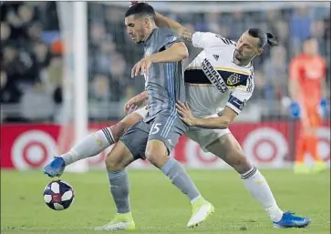  ?? Andy Clayton-King Associated Press ?? GALAXY midfielder Zlatan Ibrahimovi­c battles for the ball with Minnesota United defender Michael Boxall during the first half of a first-round playoff match. The Galaxy’s win means a showdown against rival LAFC.