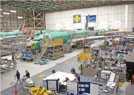  ?? (Bloomberg) ?? Employees work near a Boeing 737 Max jet at the company’s manufactur­ing facility in Renton, US