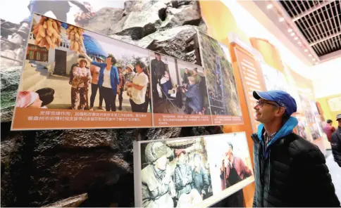  ??  ?? 2018 年12月6日，一名来自以色列的参观­者在中国国家博物馆举­行的“伟大的变革——庆祝改革开放40周年­大型展览”上观看展出的图片(潘旭/摄)