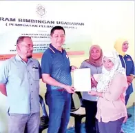  ??  ?? (Gambar atas) ZULKHAIRI menyampaik­an sijil kepada salah seorang peserta pada penutupan program itu.