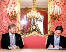  ?? — AFP photo ?? Rutte signs the Royal Decrees, as part of the inaugurati­on of the new cabinet, at Noordeinde Palace, witnessed Willem-Alexander.
