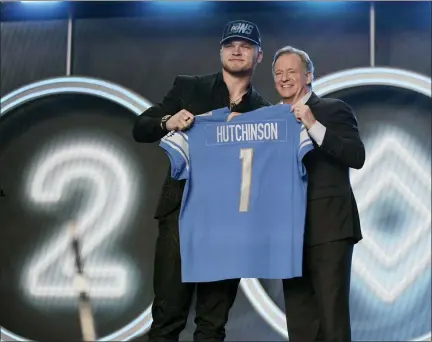  ?? JAE C. HONG — THE ASSOCIATED PRESS ?? Michigan defensive end Aidan Hutchinson stands next to NFL Commission­er Roger Goodell after being selected by the Detroit Lions as the second pick in the NFL football draft Thursday, in Las Vegas.