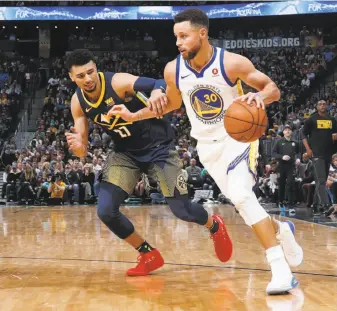  ?? David Zalubowski / Associated Press ?? Stephen Curry, driving past the Nuggets’ Jamal Murray on Saturday night, is looking to win his third MVP award in four seasons. In 2016, he was the league’s first unanimous MVP.